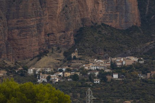 Riglos, Spain - October 15, 2020: General view of the town of Riglos, at the foot of the huge walls of the Mallets of Riglos, Huesca, Pre-Pyrenees, Aragon.