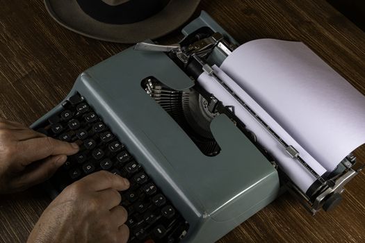 a man while writing with an old typewriter