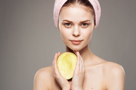 woman with bare shoulders Mango in hands exotic pure skin cropped view. High quality photo