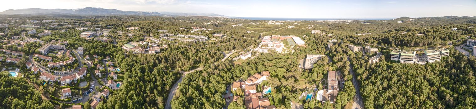 Aerial panoramic view of village with green valley and mountain on the background, South of France, Europe