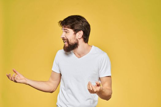 Bearded man in white t-shirt emotions close-up fun yellow background. High quality photo