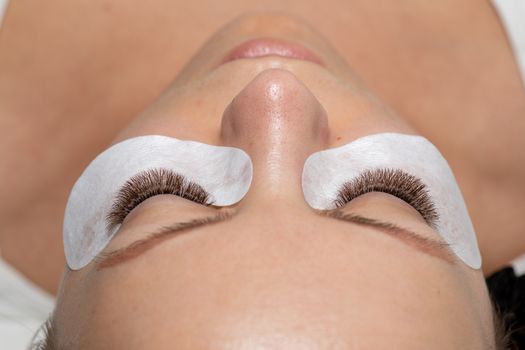 Woman closed eyes with Long Eyelashes Extension and eyepatch under eyes. False Lashes ater beauty treatment