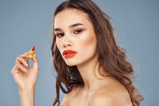 Woman with lipstick on a gray background brunette makeup with eye shadow on the eyelids. High quality photo