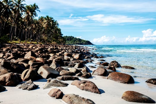 Stone on beach at sea with the blue sky.