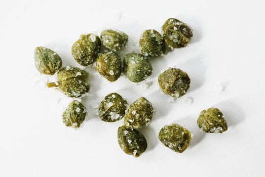 Beautiful green salted capers on white background , 