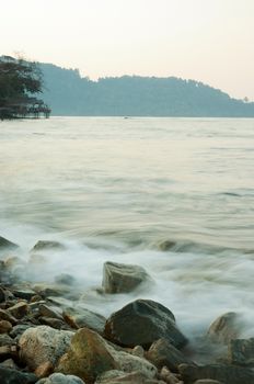 Soft waves on a rocky beach in the morning