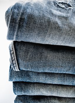 Pile of different blue jeans, fabric texture