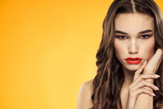 Woman with bare shoulders red cropped lips charm yellow background. High quality photo