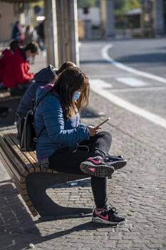 terni,italy november 03 2020:people at the station wait for the bus with a medical mask due to corona virus