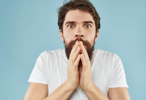 Puzzled man with a beard on a blue background emotions of surprise. High quality photo
