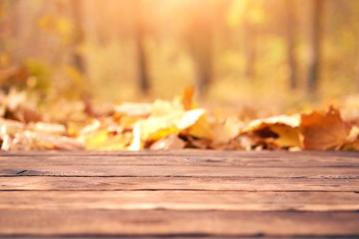 Empty wooden table autumn maple leaves nature bokeh background with a country outdoor theme,Template mock up for display of product Copy space