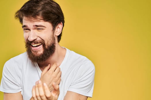 Bearded man in white t-shirt emotions close-up fun yellow background. High quality photo