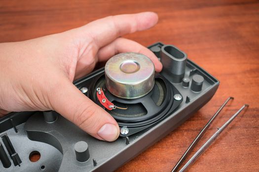 Loudspeaker repair process. The master changes the speaker by hand