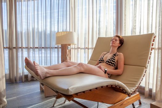 woman relaxing on a lounger in the wellness center.
