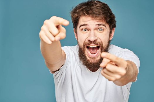 emotional man gesturing with hands lifestyle fun white t-shirt blue isolated stock. High quality photo