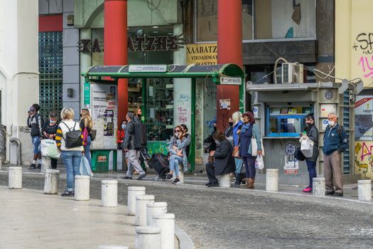 Unidentified crowd with face protection waiting for an OASTH public transportation vehicle in the city centre.