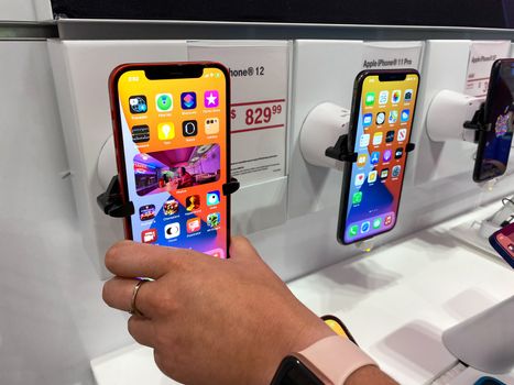 Orlando, FL/USA - 10/25/20: A person trying out the new Apple iPhone 12 and 12 Pro on display at the T Mobile store.