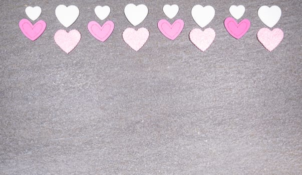 gray granite background with pink and white hearts for valentines day. Valentine's day and love concept.