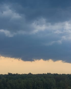 Dark blue heavy storm clouds before a thunderstorm or hurricane. Dramatic clouds in overcast weather. Cloudscape.