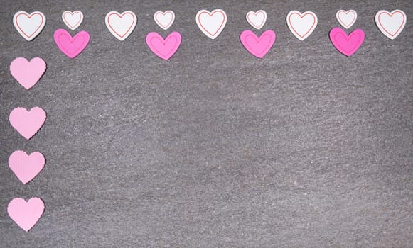 gray granite background with pink and white hearts for valentines day. Valentine's day and love concept.