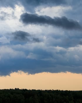 Dark blue heavy storm clouds before a thunderstorm or hurricane. Dramatic clouds in overcast weather. Cloudscape.