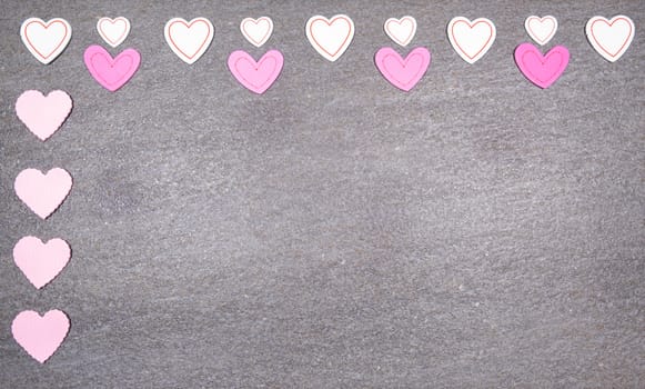 gray granite background with pink and white hearts for valentines day. Valentine's day and love concept.