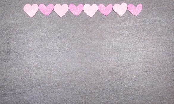 gray granite background with pink and white hearts for valentines day. Valentine's day and love concept.