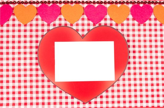 background with red and white Vichy fabric for valentine's day with red and pink hearts and a white card to put the text. valentines day concept.