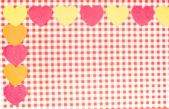 background with red and white Vichy fabric for Valentine's Day with pink, yellow and orange hearts. valentines day concept.