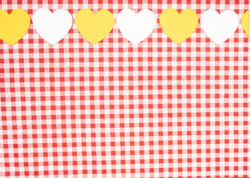 background with red and white Vichy fabric for valentines day with yellow and white hearts. valentines day concept.