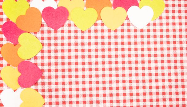 background with red and white Vichy fabric for Valentine's Day with pink, orange, yellow and white hearts. valentines day concept.