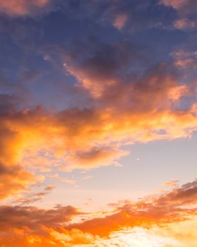 Colorful orange-purple dramatic clouds lit by the setting sun against the evening sunset sky. Cloudscape.