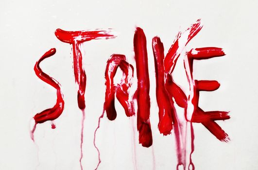 Strike text on white wet background , handwritten with red color and dissolved with water