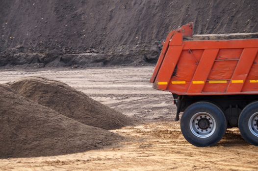 dump truck and a pile of sand at a construction site close-up