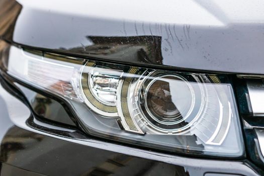 Close up photo of modern car, detail of headlight. Headlight car Projector LED of a modern luxury technology and auto detail.