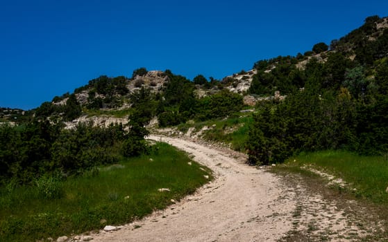Sandy mountain road of the island of Cyprus in the light of the setting sun.
