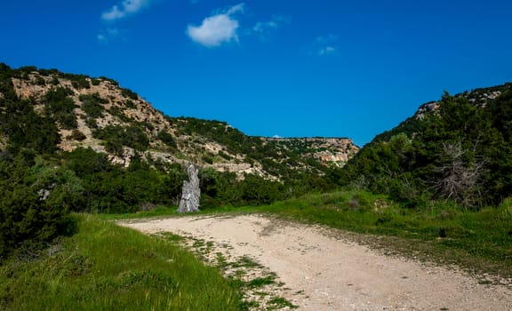 Sandy mountain road of the island of Cyprus in the light of the setting sun.