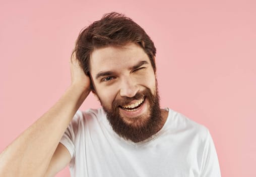 Portrait of a man with a beard and mustache on a pink background close-up cropped view. High quality photo