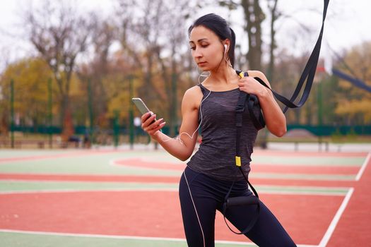 Girl athlete training using trx sportground Mixed race young adult woman workout suspension system Healthy lifestyle Stretching outdoors playground. Make your body machine