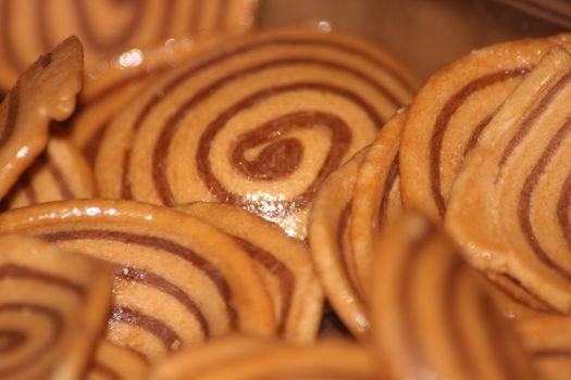 Closeup view with selective focus of a large number of round cookies with coconut filling lines.