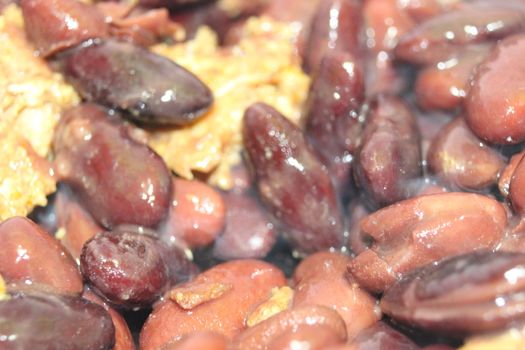 High angle close up picture of baked red kidney bean served with soup