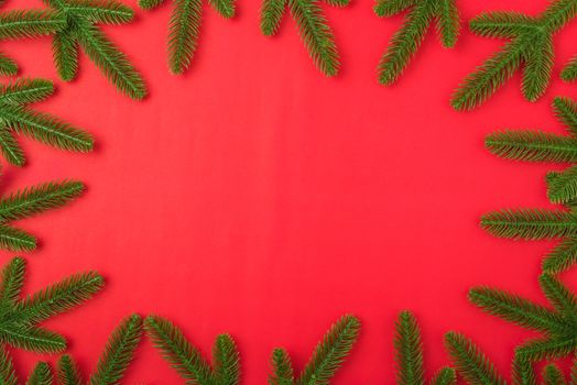 Happy new year or christmas day top view flat lay fir tree branches on red background with copy space for your text