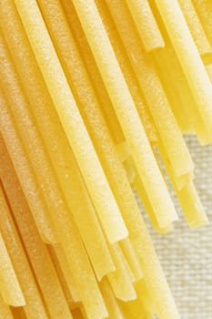 Dried pasta spaghetti  on a white background, long and thin solid cylindrical pasta , abstract effect