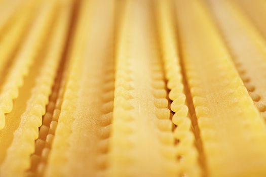 Raw Italian pasta called mafaldine  , flat and wide pasta with wavy edges on both sides  , beautiful abstract effect ,macro photography