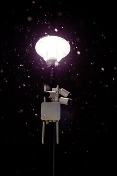 wireless cameras on night winter lamp post with snow and selective focus.
