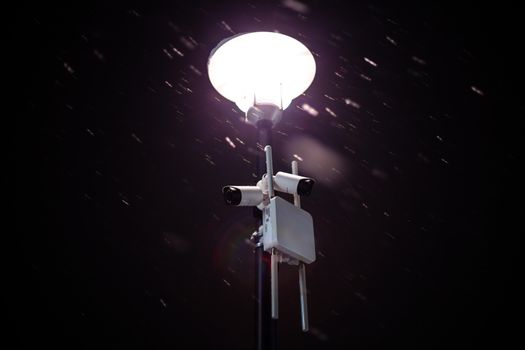 wireless cameras on night winter lamp post with snow and selective focus.