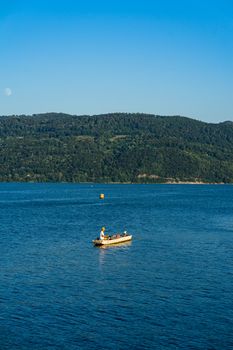 Man in boat relaxing and fishing on Danube river on a sunny day in Orsova, Romania, 2020.