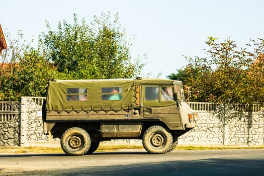 Army car in motion on asphalt road, side view of car on street. Bucharest, Romania, 2020