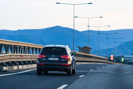 Traveling black car in motion on asphalt road, back view of car on street. Bucharest, Romania, 2020