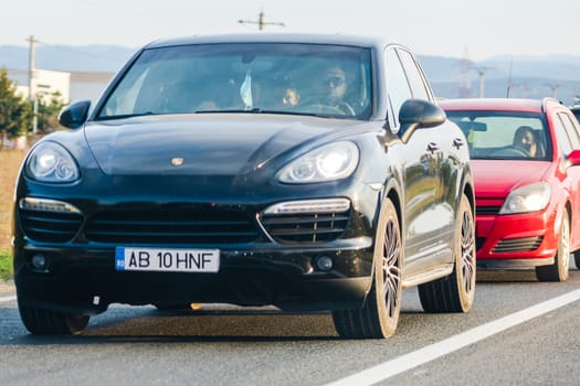 Traveling Porsche car in motion on asphalt road, front view of car on street. Bucharest, Romania, 2020